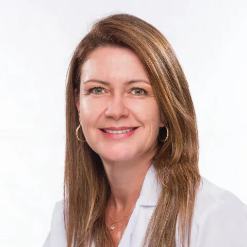 Doctora Ana María Castillo en retrato médico con fondo neutro.