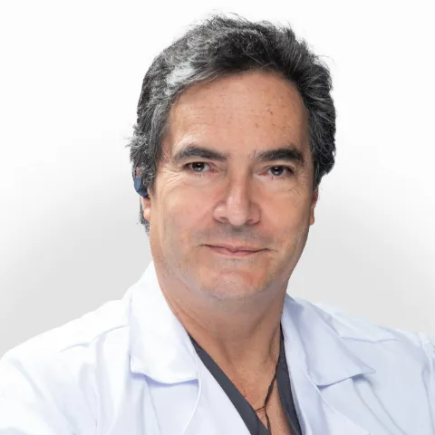 Doctor Néstor Nenroth Muñetón en retrato médico con fondo claro.
