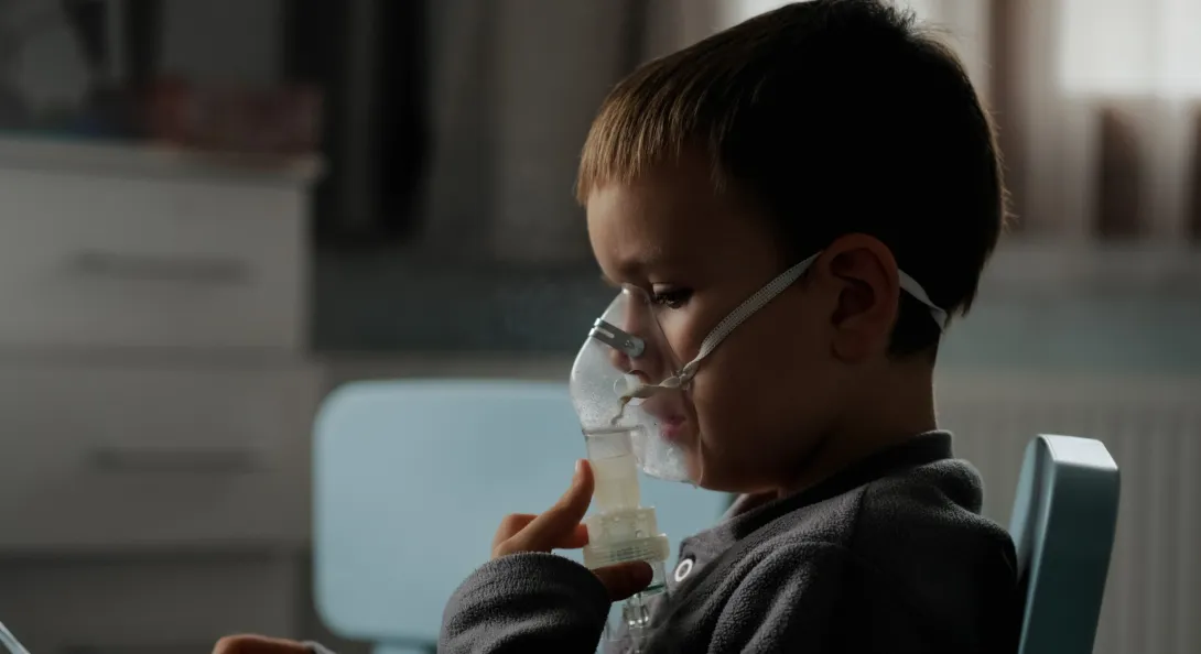 Neumóloga pediatra revisando a niño con diagnóstico de asma bronquial en consulta de Clínica Reina Sofía